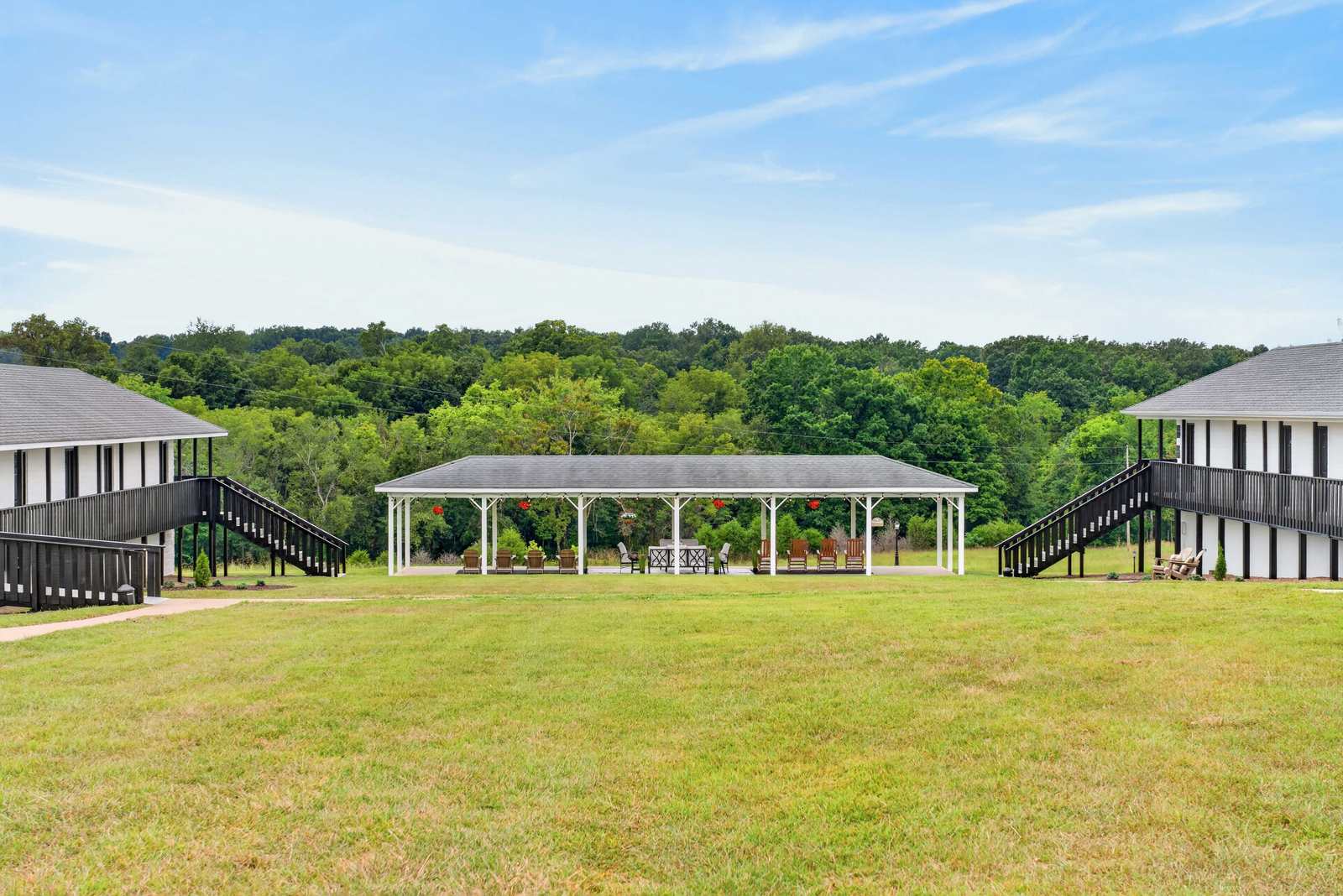 Wide green lawn between the two residence buildings looking toward the open-air pavilion