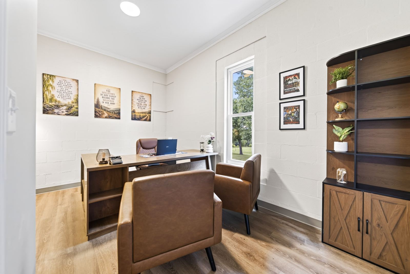A private counseling office with two leather chairs facing a desk beside a sunlit window