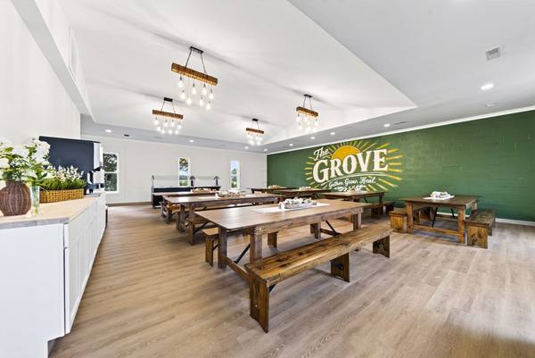Dining hall with a white serving counter, buffet line, and the green Grove mural along the far wall