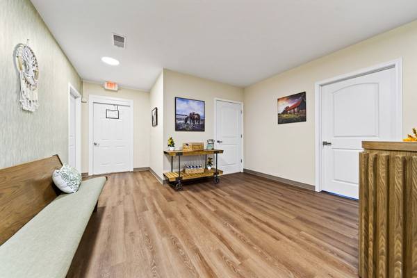 Entry hall with framed prints of horses and a red barn above a small console table