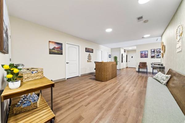 Lobby with a wooden cart holding bottled water and lemons, a long bench, and a check-in desk