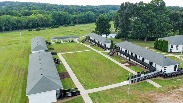Aerial of the two residence wings and the paths between them, surrounded by mown fields and trees