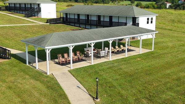 The pavilion and a residence wing seen from above, joined by concrete paths across the lawn