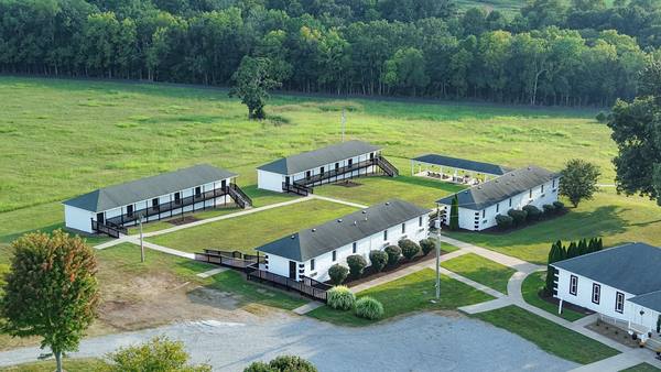 Aerial looking down on the residence buildings, the main house and the gravel drive between them